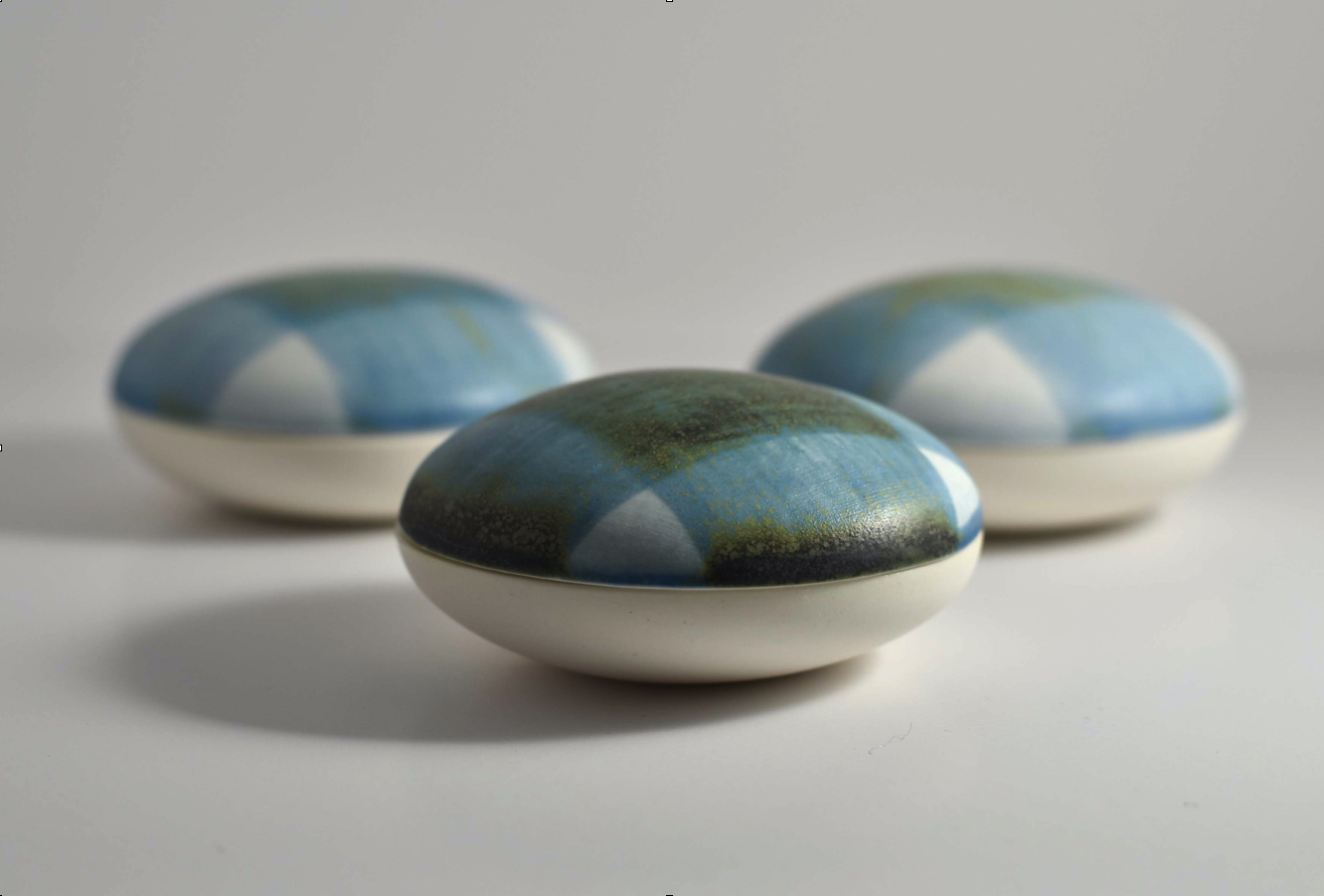 Små runda keramiska askar av Margareta Jonsson